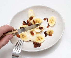 Bananas with raisins slices in a plate. Appetizing bananas in a plate.