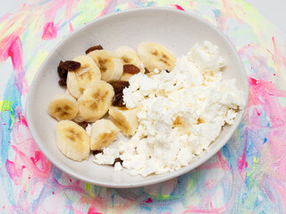Bananas with cottage cheese, cheese and raisins slices in a plate. Appetizing bananas in a plate.