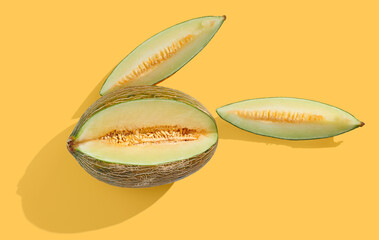 Ripe yellow honey melon on orange pastel background