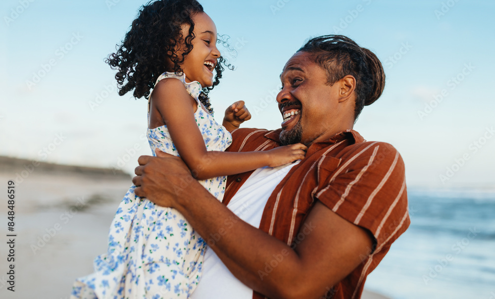 Wall mural happy father and daughter playing at the beach on a sunny day