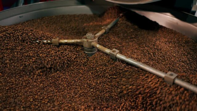vertical video close-up of a coffee roasting factory inside drum roasting stirring coffee