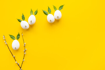 Easter eggs in shape of bunnies with spring green leaves and willow sprig. Easter festive layout