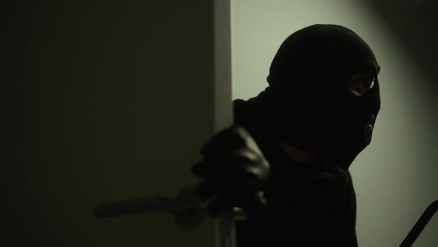 The creepy thief sneaking to enter inside the house and being caught by security camera CCTV, CCTV evidence installation for home security, criminal impact on economic society. 
