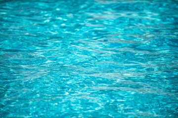 Ripple Water in swimming pool with sun reflection. Wavy water background.