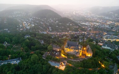 Fototapeta premium Aerial view of Marburg, Germany at dusk showcasing Marburg castle and the surrounding town.
