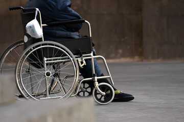 Old woman beggar in a wheelchair