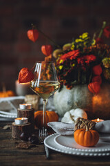 Fall table decoration with pumpkins, wine. Family cozy thanksgiving dinner arrangement indoors at home, wedding elegant decor. Countryside style, simple handmade setting, autumn mood, inspiration.