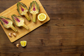 Fresh raw artichokes with lemon and garlic ready for cooking