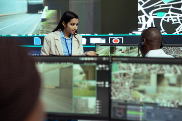 Indian supervisor gives instructions to her team in monitoring room, working on giving insight to...