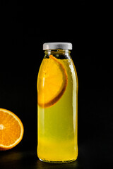 Cold summer orange drink in a glass bottle. A refreshing fruity summer drink.