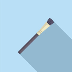 Makeup brush is lying diagonally on a blue background, casting a long shadow