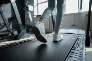 Close-Up View Of A Young Womans Feet Running On A Treadmill In A Gym