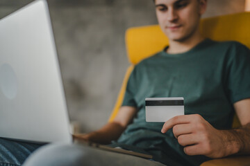 teenager young man at home use credit card shopping online e-banking