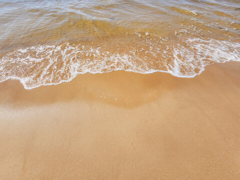 A tranquil beach scene with gentle waves lapping on a sandy shore, capturing the essence of peacefulness