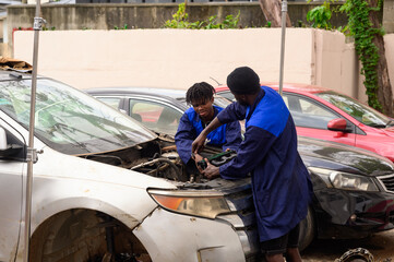 Fototapeta premium Mechanics taking out the engine cover of a car in their workshop