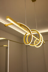 Sleek LED pendant light enhances artistic, minimalist design in room with light marble walls
