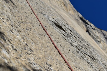 Climbing rope resting against the granite rock wall of El Capitan in Yosemite Valley