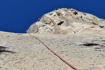 Climbing rope resting against the granite rock wall of El Capitan in Yosemite Valley