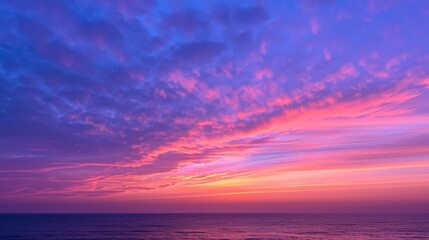 Obraz premium sunset with vivid pink and purple hues reflecting off cloud formations, above a calm ocean