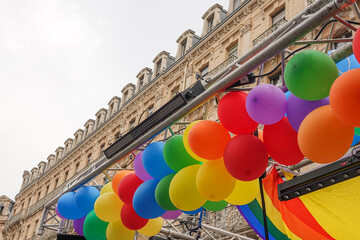 balloons in the colors of the LGBT rainbow against the background of the facade of an old European building