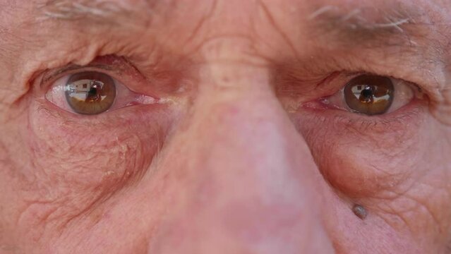 A close-up of an elderly man's eyes, revealing the intensity of his gaze and the wrinkles that mark the passage of time. His eyes convey deep emotion and wisdom.