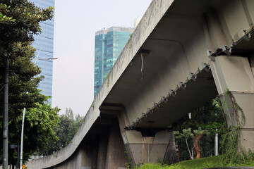 Construction of a concrete flyover bridge in an office building environment, showcasing modern engineering and urban infrastructure development