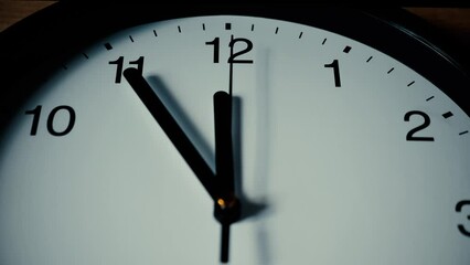 Wall clock dial. Second arrow hand moves counterclockwise back from twelve. Time is 5 minutes to midnight. Concept of passing time, procrastination, countdown, time machine. Creative plot