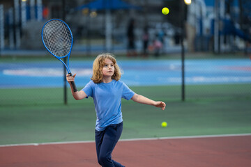 Cute Kid play tennis. Little kid hit tennis ball with tennis racket. Active exercise for kids....