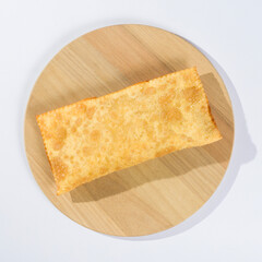 Brazilian fried pastry on a wooden plate on white background topview