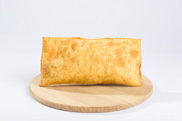 Brazilian fried pastry on a wooden plate on white background