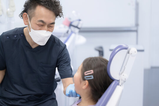 歯医者で働く医師と患者の子供　小児歯科のイメージ　クローズアップ