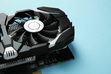 Computer graphics card on light blue background, closeup. Space for text