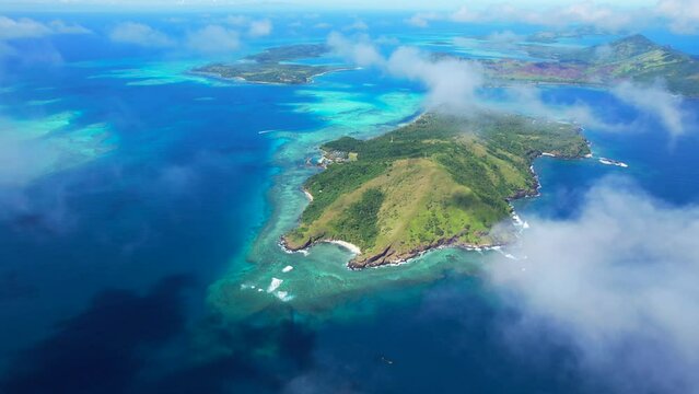 Aerial flyover above the Yasawa Islands - Looking at the pristine remote Islands and the surrounding coral reefs from above	