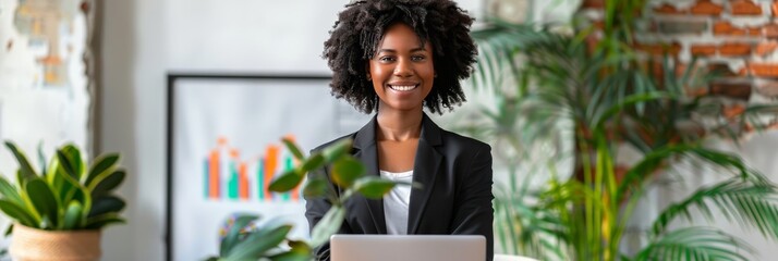 Confident businesswoman presenting project in modern boardroom with colleagues, laptop, and graph