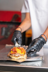 Chef preparing a bacon cheeseburger to go