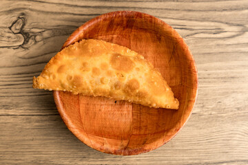 one empanada in a bowl