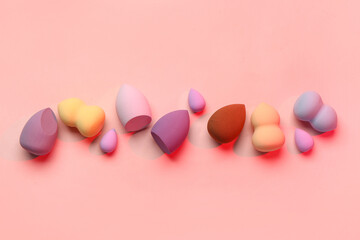 Different makeup sponges on pink background