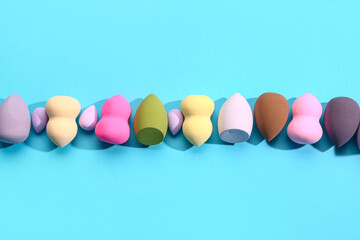 Different makeup sponges on blue background