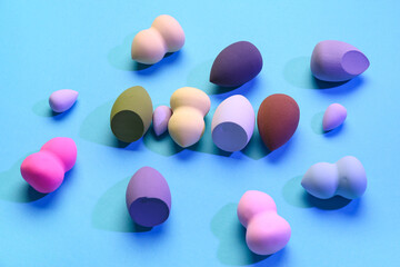 Different makeup sponges on blue background