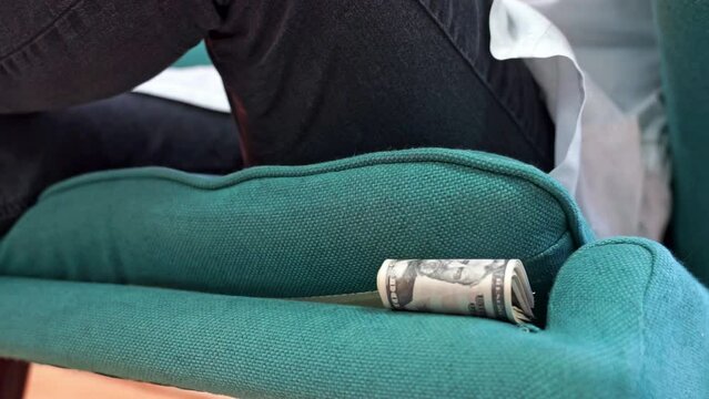 Doctor in white coat, jeans sits voluptuously on chair, hiding money and folded dollar bills under pillow Corrupt medicine, bribes in pharmaceuticals. Issuing illegal drug prescriptions Deal, get paid