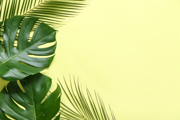 Different tropical leaves on yellow background