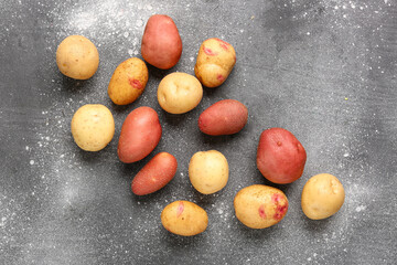 Fresh raw potatoes on grey background