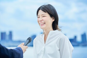 屋外でインタビューを受ける若い女性