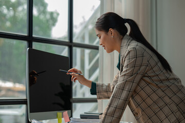 a businesswoman works at her desk, an entrepreneur is sitting and working in front of the computer to research for information on new project, female employee is in the office