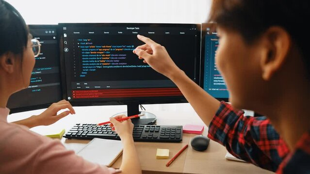 Slow motion back end software developer engineer for computer programming working together on debugging writing computing code, solving complex algorithms display on monitor in office. Burgeoning