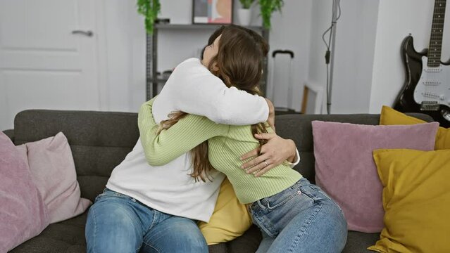 Woman and man embracing lovingly on a home couch, reflecting a warm, affectionate relationship amid cozy decor.