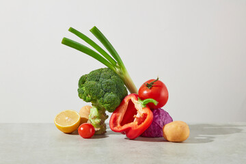 White background photo with frontal view, a pile of fresh vegetables displayed in the center,...