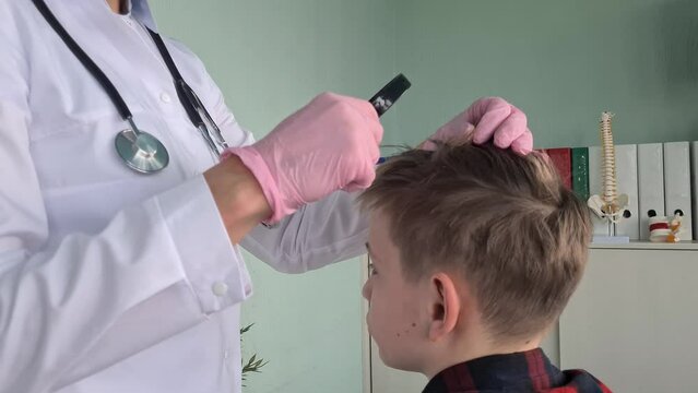 Doctor Examines Boys Scalp for Lice in Clinic
