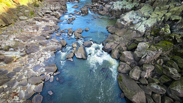 The South Esk River, shallow in its course, cascades over a bed of moss-covered igneous dolerite rock, creating a sequence of cataracts.