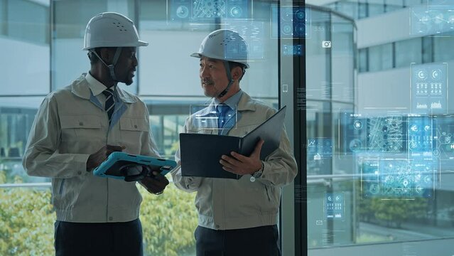 ロビーで会話する多国籍エンジニアとデジタルテクノロジー